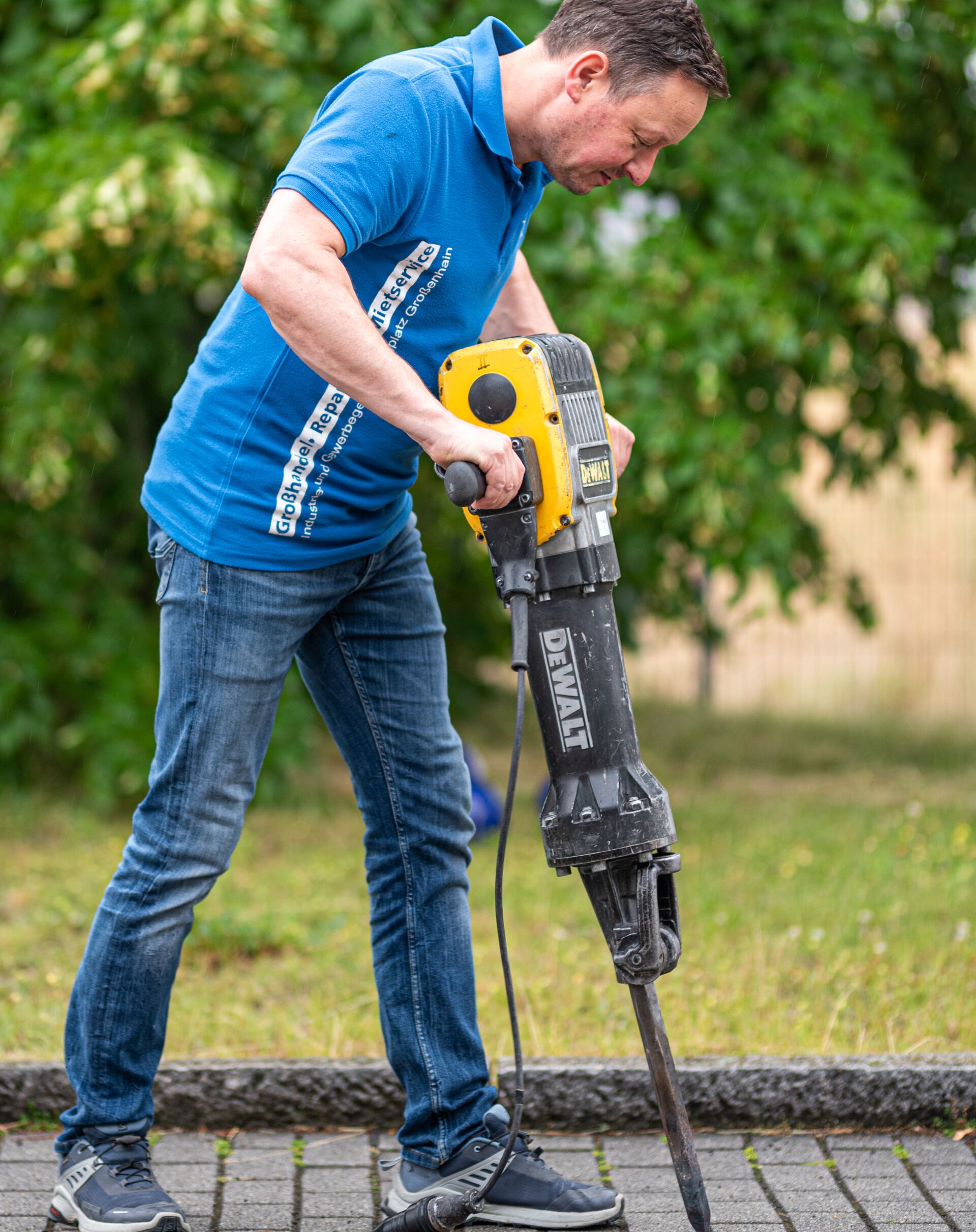 Ein Mann bohrt mit einem Bohrhammer auf einem Gehweg